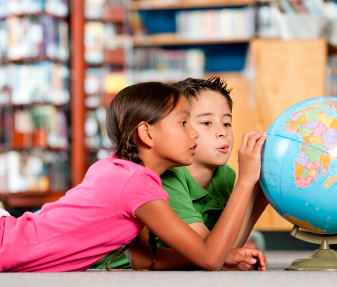 children gazing at globe